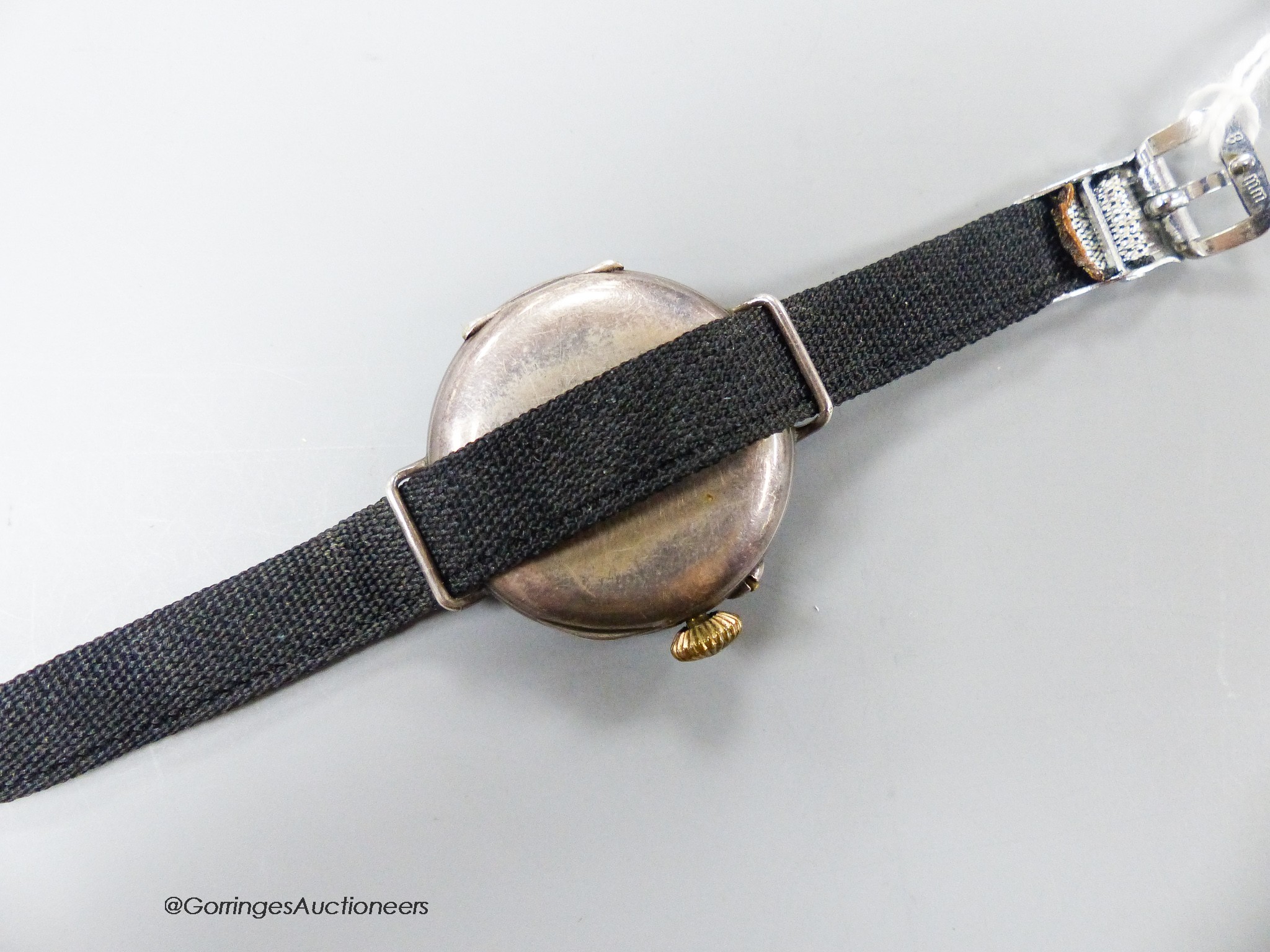 A lady's early 20th century silver and enamelled manual wind wrist watch, on a fabric strap.